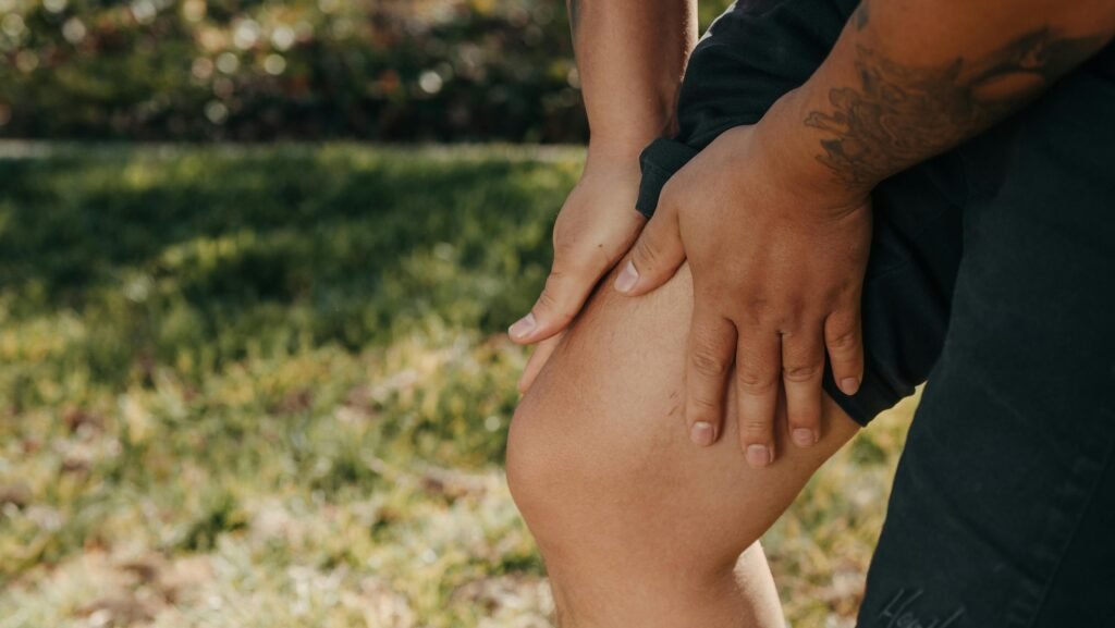 chronic pain knee related Man outdoors holding his knee and upper thigh due to chronic pain and a need for release and pain management