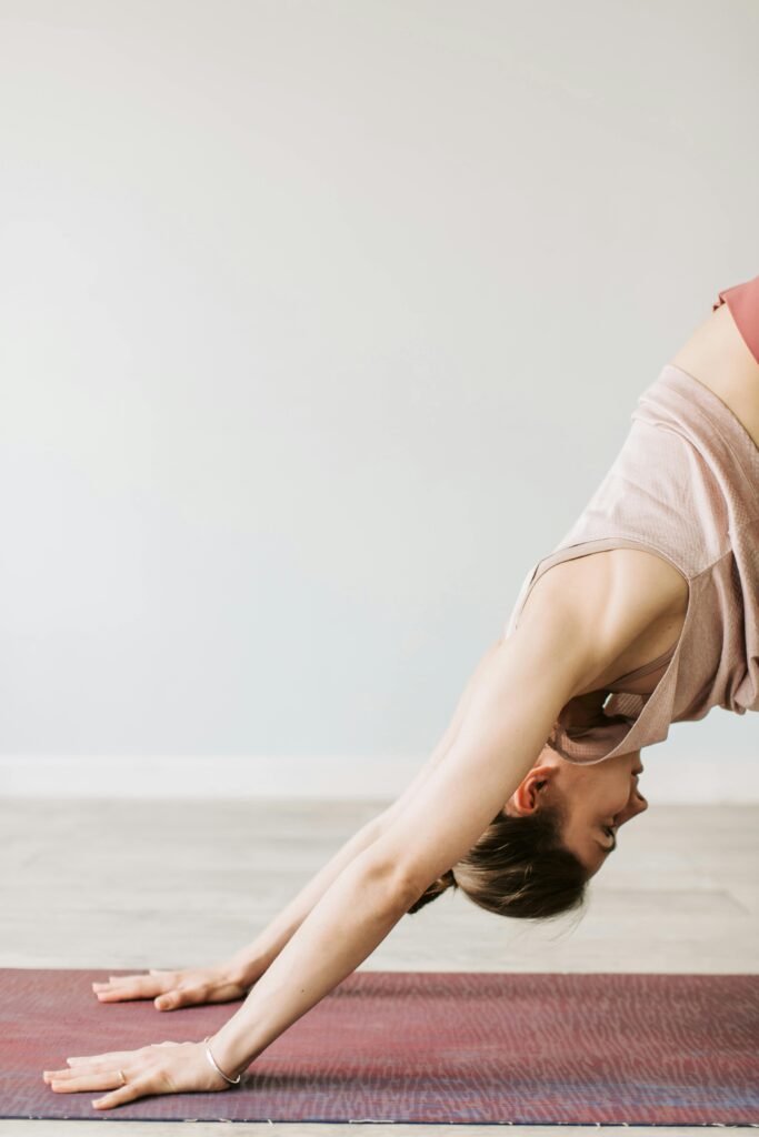 downward dog for fasciitis Woman indoors in a soft and soothing room on a yoga mat in a downward dog position to alleviate pain from plantar fasciitis