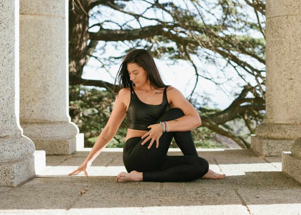 Young woman in a green and isolated space doing a gentle stretch or yoga poses for migraines relief