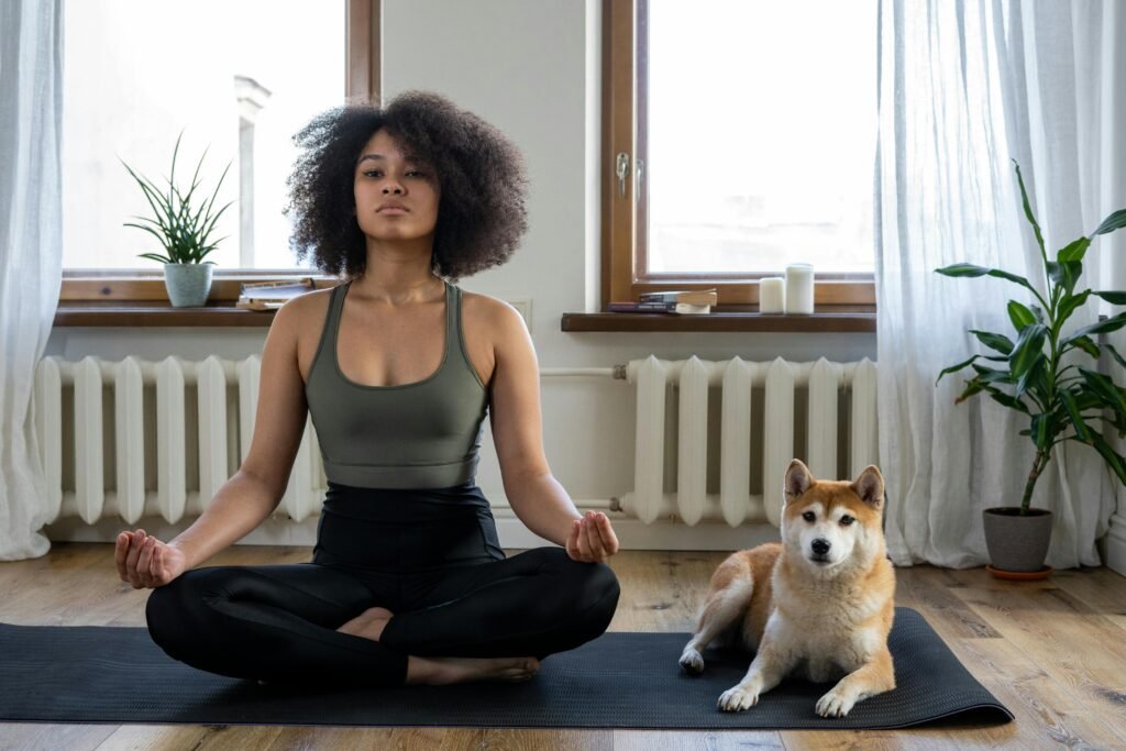 Young woman and her dog on a yoga mat  in a bright aesthetic room performing breathing exercises and mindful yoga 