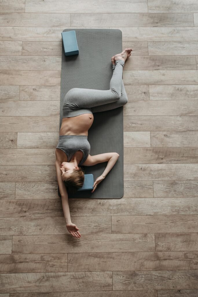 Woman lying on a prop-supported mat doing a routine based around prenatal yoga