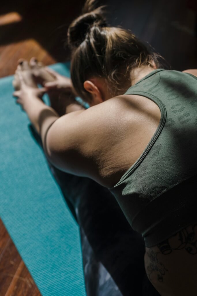 restorative childs pose Woman indoors in a dark soothing room on a yoga mat performing a restorative child's pose to alleviate chronic pain