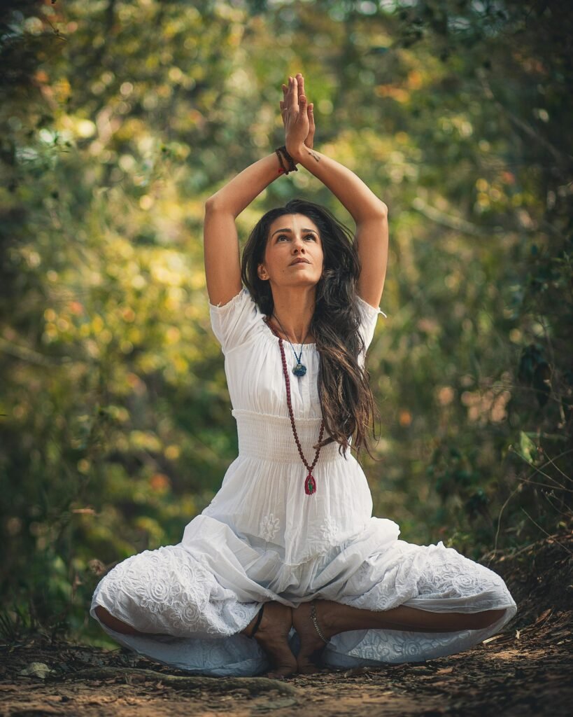 restorative yoga poses Woman outdoors in a tranquil and green space practicing restorative yoga poses for pain relief