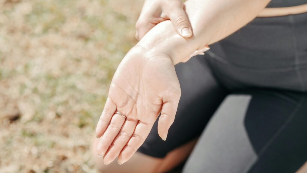 Woman holding her wrist outdoors while performing a static wrist stretch to relieve pain