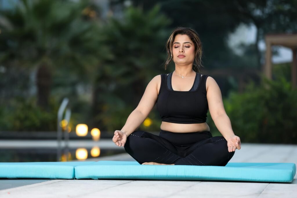 young woman practicing mindfulness and breath work on a yoga mat outdoors
